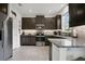 Modern kitchen featuring dark cabinetry, stainless steel appliances, and granite countertops at 2009 Napoli Dr, St Cloud, FL 34771