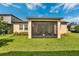 View of the screened-in lanai of this home featuring neutral paint and lush green grass at 2009 Napoli Dr, St Cloud, FL 34771