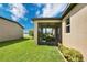 Outdoor screened-in patio area with views of the green yard and a glimpse of a lake nearby at 2009 Napoli Dr, St Cloud, FL 34771