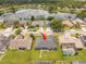 Aerial view of the property featuring a lush backyard, neighboring homes, and a serene lake nearby at 2547 Raccoon Run Ln, Orlando, FL 32837