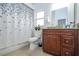 Cozy bathroom featuring a vanity with granite countertop and a shower with a decorative curtain at 2547 Raccoon Run Ln, Orlando, FL 32837