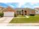 Lovely brick home with manicured landscaping, an attached garage, and a welcoming front entrance at 2547 Raccoon Run Ln, Orlando, FL 32837