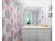Bright bathroom featuring a shower with a fun patterned curtain, light vanity, and decorative Mickey Mouse art at 2550 Renshaw St, Kissimmee, FL 34747
