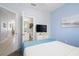 Bright bedroom with a bed, TV, and attached bathroom access in a clean, modern interior at 2550 Renshaw St, Kissimmee, FL 34747