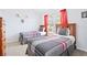 Bedroom featuring two twin beds with red accents, carpeted floors, and natural light at 2550 Renshaw St, Kissimmee, FL 34747