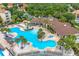 Aerial view of the community pool area, including palm trees, a hot tub, and lounge chairs at 2550 Renshaw St, Kissimmee, FL 34747