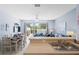 View of a casual living room with a dining table, blue couches and an outdoor view through glass doors at 2550 Renshaw St, Kissimmee, FL 34747