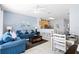 Open-concept living room with tile flooring, blue couches, dining area, and a breakfast bar looking into the kitchen at 2550 Renshaw St, Kissimmee, FL 34747