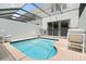 Private pool in a screened in enclosure with lounge chairs and a safety fence at 2550 Renshaw St, Kissimmee, FL 34747