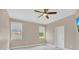 This bedroom features a modern ceiling fan, neutral walls, and two windows for added comfort at 2663 Youngford St, Orlando, FL 32824