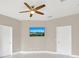 This bedroom features a modern ceiling fan, neutral walls, and a wall-mounted TV for added comfort at 2663 Youngford St, Orlando, FL 32824