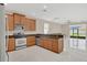 Open kitchen with wood cabinets, stainless steel appliances, and granite countertops, seamlessly connected to the living area at 2663 Youngford St, Orlando, FL 32824