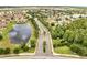 An aerial view of a Primary-planned community with tree-lined streets, a tranquil lake, and meticulously landscaped common areas at 2810 Maguire Dr, Kissimmee, FL 34741