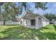 A home's backyard with a covered patio, open green space, providing a private and relaxing atmosphere at 2810 Maguire Dr, Kissimmee, FL 34741