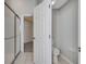 Bathroom featuring a toilet and glass door shower, with an open door at 2810 Maguire Dr, Kissimmee, FL 34741