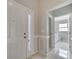 Foyer featuring a glass panel front door, neutral paint, tile flooring, and bathroom access at 2810 Maguire Dr, Kissimmee, FL 34741