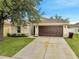 Charming single-story home with a well-maintained lawn and a two-car garage at 2810 Maguire Dr, Kissimmee, FL 34741