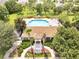 Aerial view of the community pool with tile roof clubhouse, mature landscaping and waterfall feature at 2810 Maguire Dr, Kissimmee, FL 34741