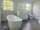 Modern bathroom featuring a soaking tub, tiled walls, and a vanity with drawers at 283 Pine Arbor Dr, Orlando, FL 32825