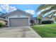 Single-Gathering home featuring an attached two-car garage and mature landscaping at 283 Pine Arbor Dr, Orlando, FL 32825