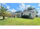 Inviting one-story home featuring a well-maintained lawn and lush palm trees at 283 Pine Arbor Dr, Orlando, FL 32825