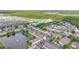 Aerial view of the townhome community near a wooded area with a pond and fountain feature at 2855 Club Cortile Cir, Kissimmee, FL 34746