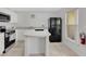 Efficient kitchen design with white cabinets, island, and black appliances at 2855 Club Cortile Cir, Kissimmee, FL 34746