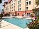 Inviting outdoor pool area with comfortable lounge chairs, lush greenery, and serene atmosphere at 3000 Maingate Ln # 325, Kissimmee, FL 34747