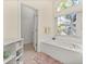 Bright bathroom with tile flooring, a soaking tub and a large window allowing ample natural light at 305 Grand Reserve Dr, Davenport, FL 33837