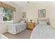Bright bedroom featuring two twin beds, neutral carpet, and a sunny window at 305 Grand Reserve Dr, Davenport, FL 33837