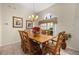 Cozy dining room with rustic wooden table and chairs, tiled floors, and traditional style chandelier at 305 Grand Reserve Dr, Davenport, FL 33837