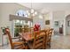 Comfortable dining room features a large window, wooden table and chairs, tile floor, and traditional light fixture at 305 Grand Reserve Dr, Davenport, FL 33837
