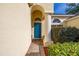 Inviting front entrance featuring a blue door with an arched entryway and manicured landscaping at 305 Grand Reserve Dr, Davenport, FL 33837