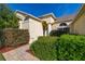 A bright and inviting home featuring manicured bushes and a paved walkway to the front door at 305 Grand Reserve Dr, Davenport, FL 33837