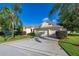 Well-maintained home featuring a manicured lawn, mature palm trees, and a three-car garage at 305 Grand Reserve Dr, Davenport, FL 33837