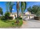 Well-maintained home featuring a manicured lawn, mature palm tree, and a two-car garage at 305 Grand Reserve Dr, Davenport, FL 33837