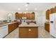 Kitchen featuring wooden cabinets, a center island, and white appliances at 305 Grand Reserve Dr, Davenport, FL 33837
