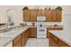 Kitchen featuring wooden cabinets, white appliances, and lots of counter space at 305 Grand Reserve Dr, Davenport, FL 33837