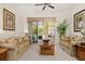 Cozy living room with plush sofas and view to the lanai and dining area at 305 Grand Reserve Dr, Davenport, FL 33837
