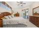 Bright main bedroom features a ceiling fan, wood furnishings, and sliding glass door access to the pool at 305 Grand Reserve Dr, Davenport, FL 33837