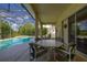 Covered patio area featuring an outdoor dining set, adjacent to a screened-in pool at 305 Grand Reserve Dr, Davenport, FL 33837