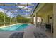 Spacious patio with lounge chairs and seating overlooking a beautiful screened pool at 305 Grand Reserve Dr, Davenport, FL 33837