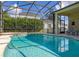 A view of a screened pool surrounded by lush greenery, adjacent to outdoor seating areas at 305 Grand Reserve Dr, Davenport, FL 33837