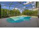 Inviting screened-in pool and spa area surrounded by lush landscaping, perfect for relaxation and privacy at 305 Grand Reserve Dr, Davenport, FL 33837