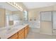 Well-lit bathroom features double sinks, a bathtub, and a separate glass-enclosed shower at 3125 Grasmere View Pkwy, Kissimmee, FL 34746