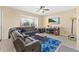 Comfortable living room with a large sectional sofa, bright blue rug, and a ceiling fan at 3125 Grasmere View Pkwy, Kissimmee, FL 34746