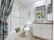 Well-lit bathroom with white tiled shower, vanity, decorative mirror and updated features at 336 Hollingshead Loop, Davenport, FL 33896