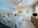 Comfortable bedroom with blue accent wall, ceiling fan and hardwood floors at 336 Hollingshead Loop, Davenport, FL 33896