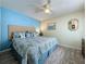 Comfortable bedroom with blue accent wall, ceiling fan and hardwood floors at 336 Hollingshead Loop, Davenport, FL 33896