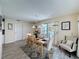 Well-lit dining area featuring wood-look floors, neutral walls, and an accent chair, creating a comfortable ambiance at 336 Hollingshead Loop, Davenport, FL 33896